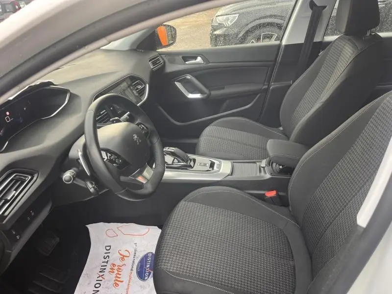 Intérieur avant droit de la Peugeot 308 2021 blanc Banquise, sièges tissu Meco Mistral et console centrale avec boîte auto.