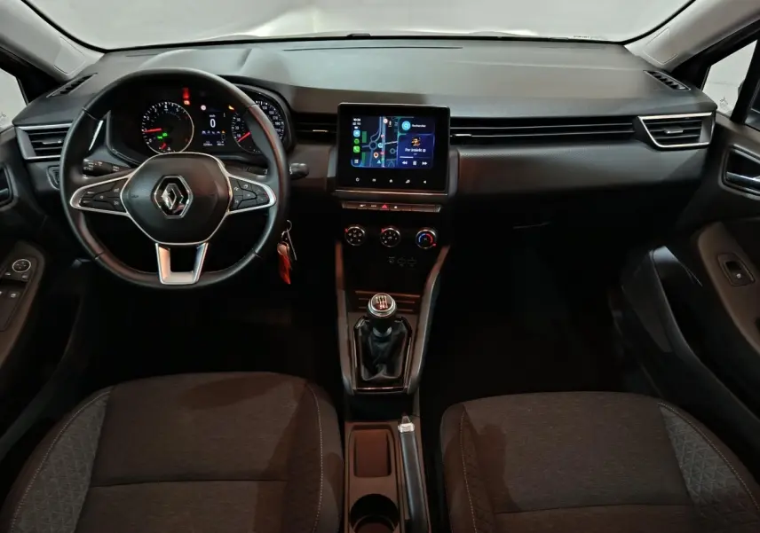 Vue intérieure avant de la Renault Clio gris clair 2023, volant cuir multifonctions et écran tactile central visible.