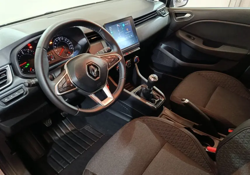 Vue intérieure côté conducteur de la Renault Clio gris clair 2023, volant cuir multifonctions et écran tactile central.