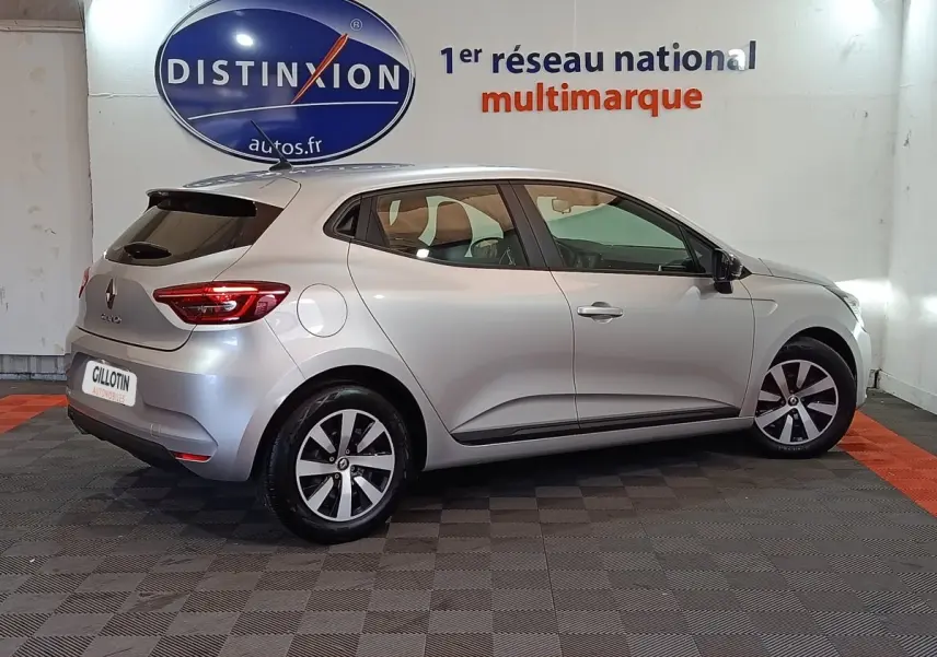 Profil droit d'une Renault Clio gris clair 2023 en version Equilibre TCe 90, avec jantes alliage et feux arrière LED visibles.