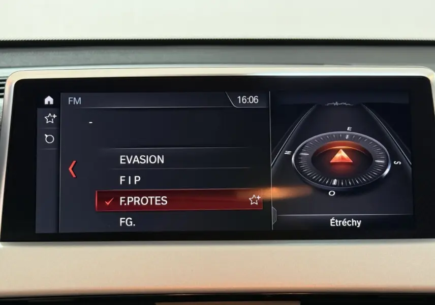 Écran central du tableau de bord de la BMW X2 sDrive18i Lounge 2023 affichant la navigation et la radio FM.