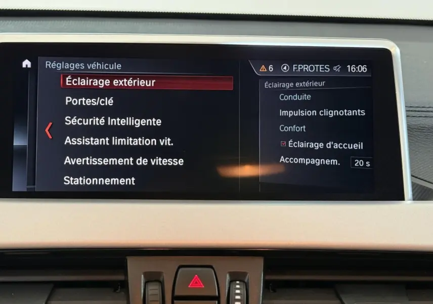 Écran central du tableau de bord BMW X2 sDrive18i 2023 montrant les réglages d’éclairage extérieur.