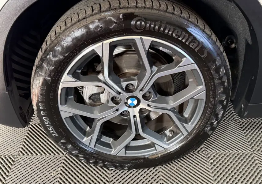 Gros plan sur la jante alliage grise et pneu Continental du BMW X2 sDrive18i Lounge blanc, roue avant droite.