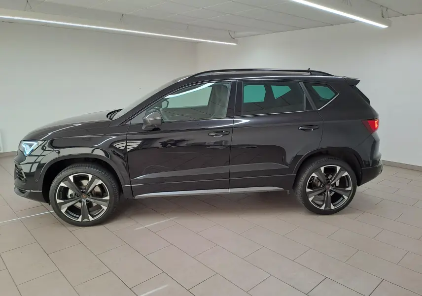 Vue de profil côté gauche d'un CUPRA Ateca 2024 noir magique avec jantes alliage distinctives en intérieur neutre.