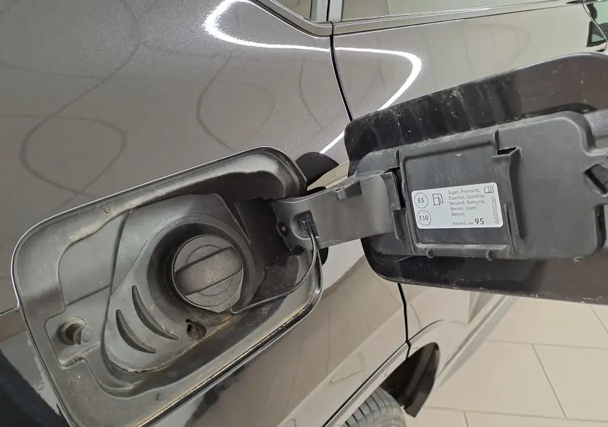Gros plan sur la trappe à carburant ouverte côté gauche d’un CUPRA Ateca Noir Magique 2024, essence E5/E10.
