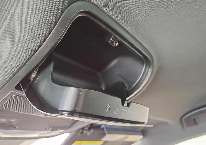 Boîte à lunettes ouverte dans le plafond intérieur du CUPRA Ateca 2024 noir magique, vue en léger contre-plongée.