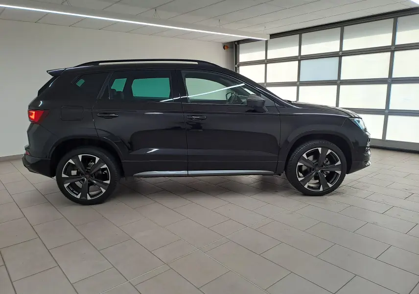 Vue de profil côté gauche d'un CUPRA Ateca 2024 noir magique, avec jantes alliage noires et toit ouvrant visible.