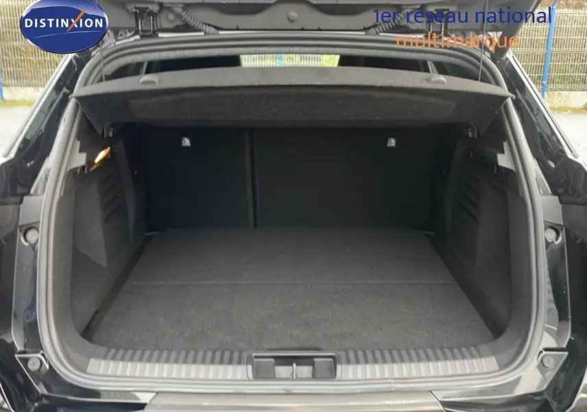 Coffre ouvert en vue arrière d'une Renault Symbioz noire étoile métal, montrant un espace de chargement spacieux et propre.