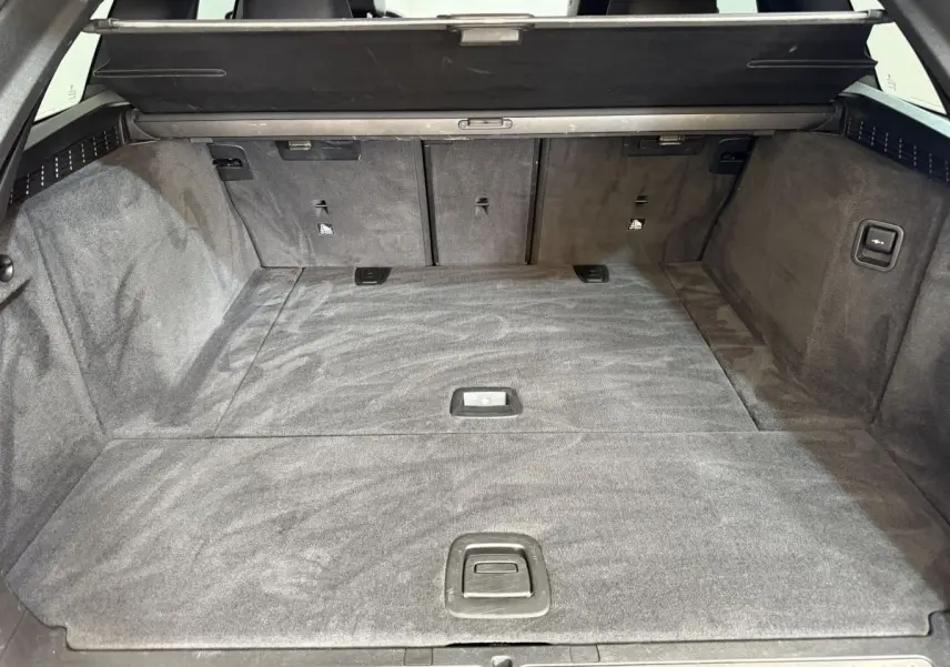 Vue intérieure du coffre spacieux et tapissé en noir de la BMW Série 5 Touring 520d M Sport 2023.