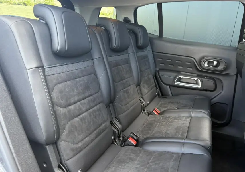 Vue latérale droite des sièges arrière noirs en alcantara et cuir du Citroën C5 Aircross 2026 avec habillage de porte assorti.