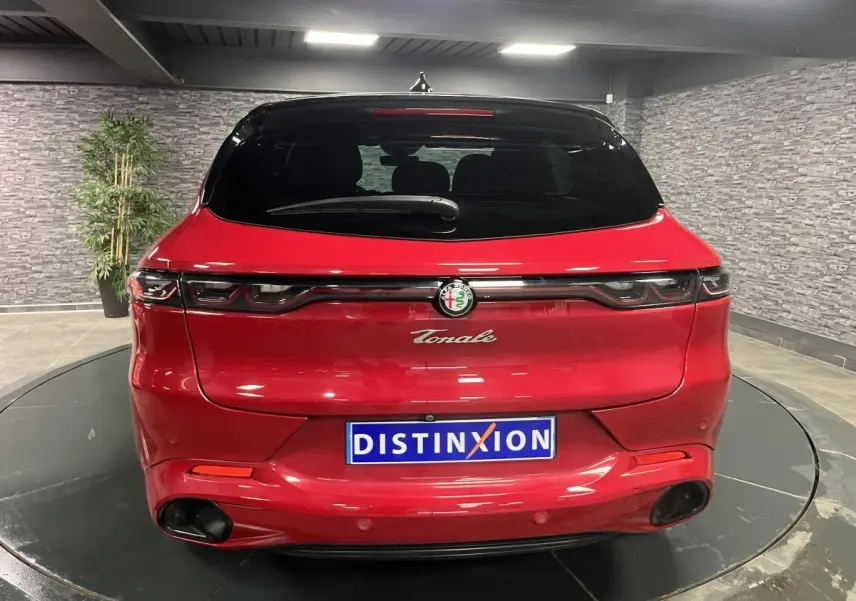 Vue arrière d'une Alfa Romeo Tonale rouge 2024 avec feux LED reliés et double sortie d'échappement noire.
