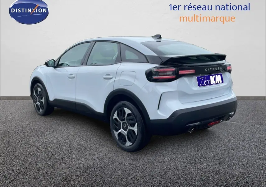 Vue 3/4 arrière droite d'une Citroën C4 blanche métal 2026 avec feux arrière noirs et jantes distinctives.