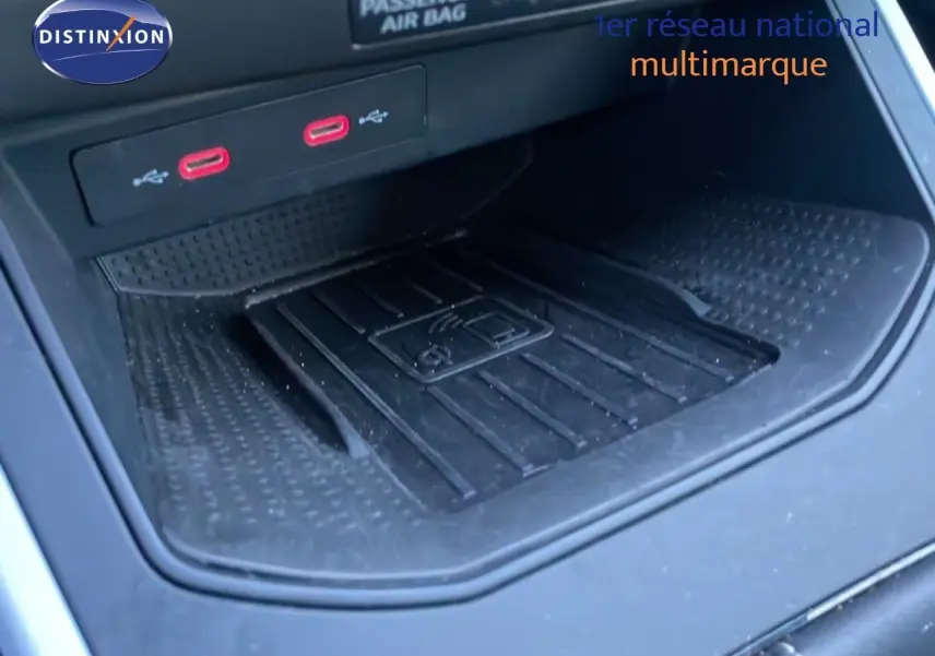 Gros plan sur la console centrale du SEAT Arona 2025, montrant un espace de recharge sans fil et deux ports USB rouges.