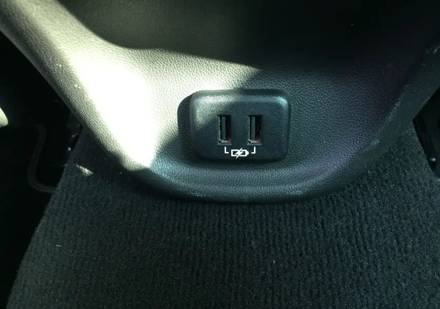 Prise double USB noire intégrée sous la console centrale d’un Opel Insignia Grand Sport blanc nacré 2017.