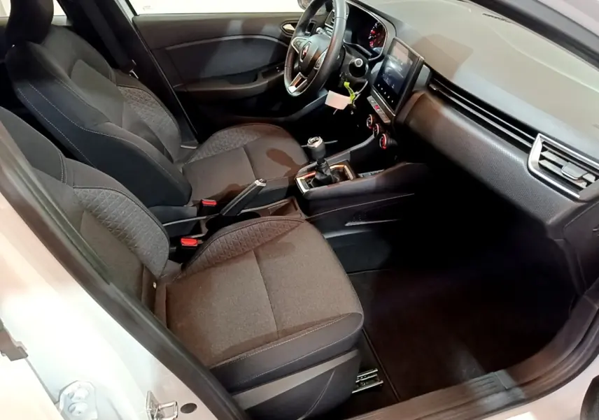 Intérieur avant droit de la Renault Clio Business blanche 2021, montrant sièges tissu et tableau de bord avec écran tactile.