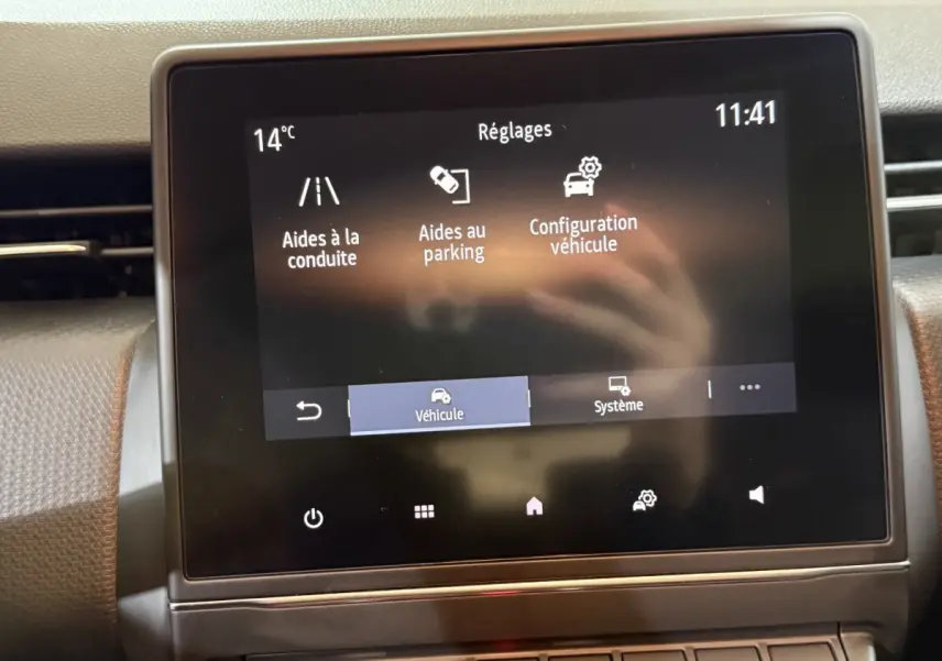 Écran tactile central de la Renault Clio Business blanc, affichant les réglages d’aides à la conduite et parking.