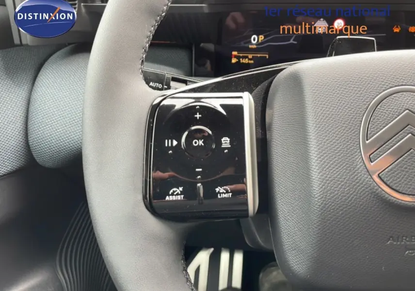 Gros plan sur le volant gris noir du Citroën C5 Aircross 2026, avec commandes intégrées et logo Citroën visible.