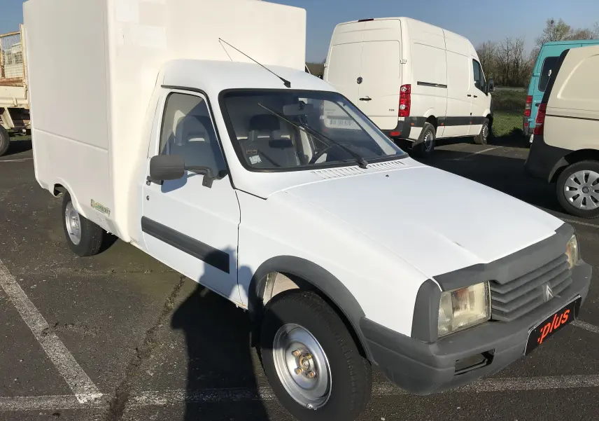 Vue 3/4 avant gauche d'un utilitaire Citroën C15 Isotherm blanc de 1997 avec caisse frigorifique sur parking.