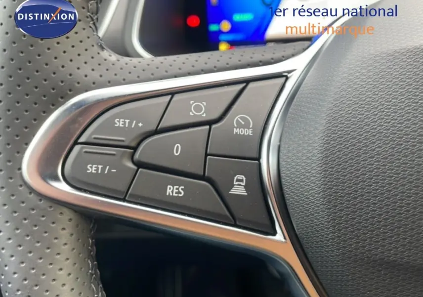 Gros plan sur les commandes du volant en cuir perforé d'une Renault SYMBIOZ noire étoile métal, version hybride 2025.