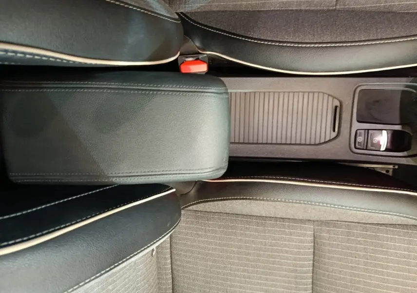 Vue plongeante sur la console centrale et les sièges noirs avec surpiqûres blanches de la Renault Clio Techno TCe 90 rouge 2024.