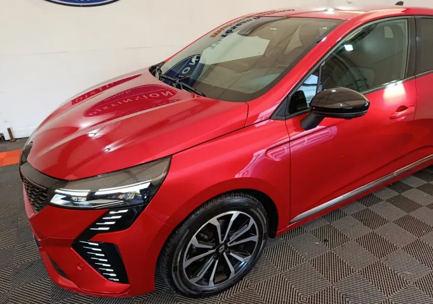 Vue 3/4 avant droit d'une Renault Clio Techno TCe 90 rouge avec phares LED et jantes alliage noires.