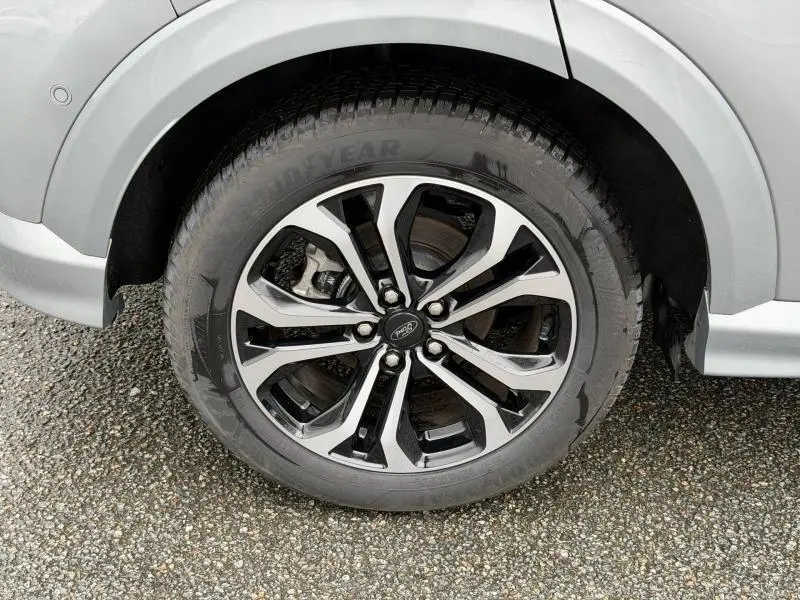 Gros plan sur la roue avant droite du Ford Puma gris Solar Métallisée avec jante alu bicolore et pneu Goodyear.