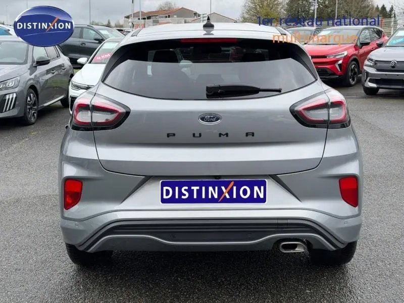 Vue arrière d'une Ford Puma 2024 gris Solar métallisée avec feu arrière LED et sortie d'échappement chromée visible.