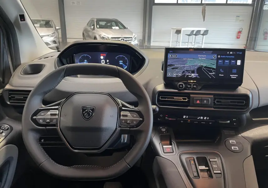 Vue intérieure du poste de conduite du Peugeot Rifter gris Artense, avec volant multifonction et écran tactile central.