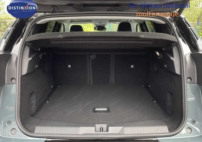 Coffre ouvert vu de l'arrière d'un Citroën C5 Aircross 2026 vert Astoria Metal, espace de chargement spacieux et tapis noir.
