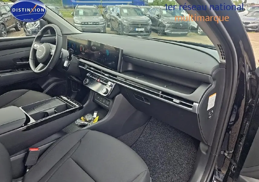 Intérieur noir du Hyundai Tucson 2025 vu côté passager, avec tableau de bord moderne et écran tactile large.