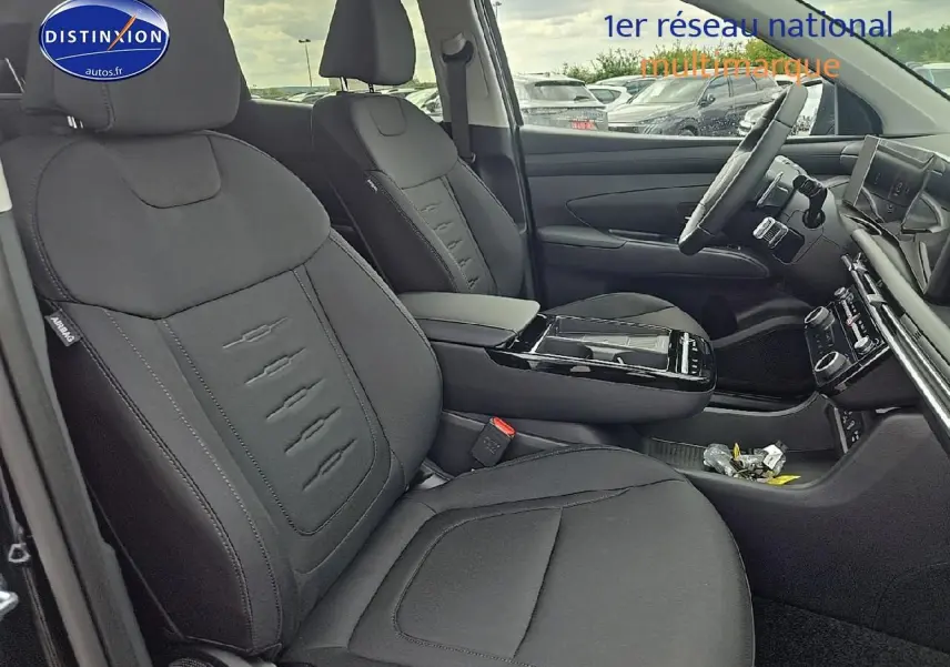 Intérieur avant du Hyundai Tucson 2025 noir abysse, montrant sièges tissu noirs et tableau de bord moderne.