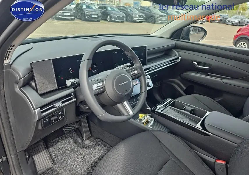 Intérieur noir du Hyundai Tucson 2025, vue côté conducteur sur le tableau de bord et volant multifonction cuir.