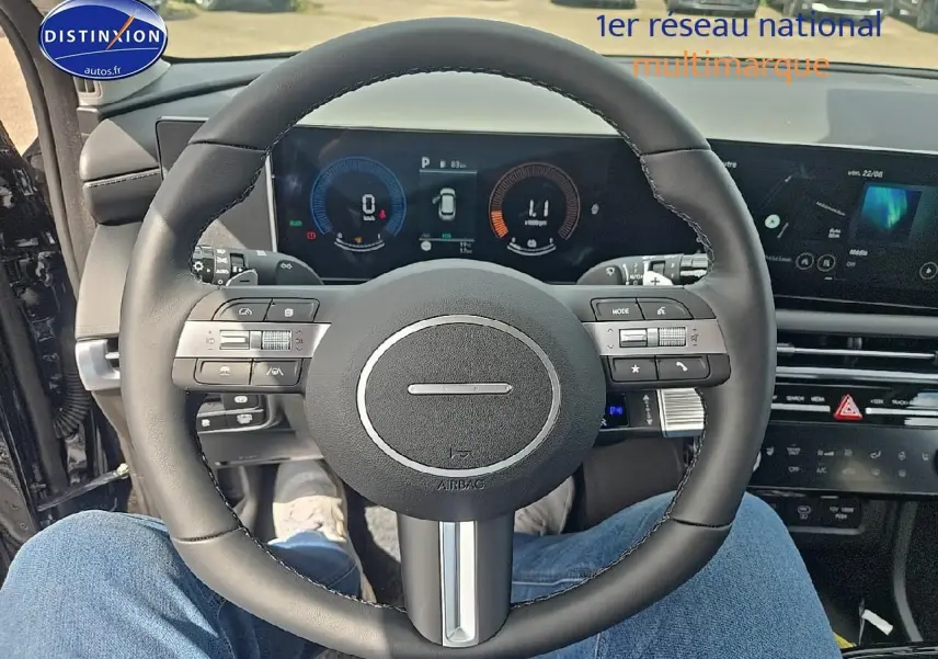 Vue depuis le siège conducteur sur le volant cuir noir et le tableau de bord numérique du Hyundai Tucson 2025 noir abysse.