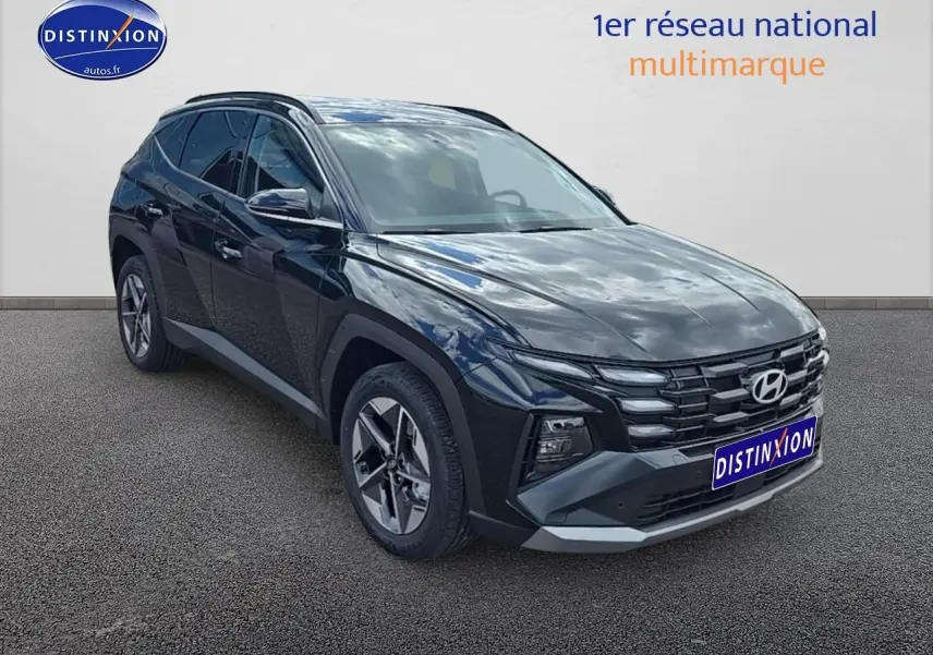 Vue 3/4 avant du Hyundai Tucson 2025 noir abysse avec jantes alliage et barres de toit visibles.