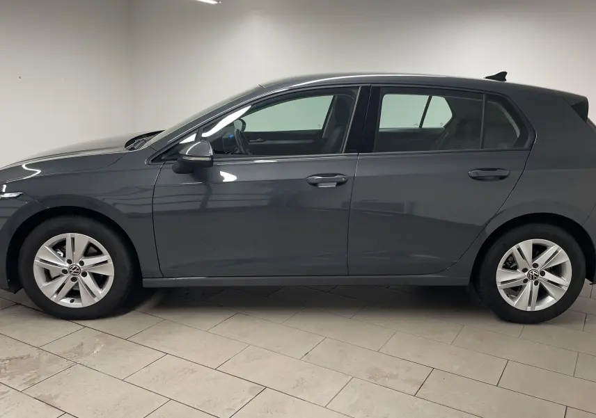 Profil côté gauche d'une Volkswagen Golf 1.5 TSI 116 BVM6 VW Edition gris dauphin métallisé, année 2024, en intérieur.