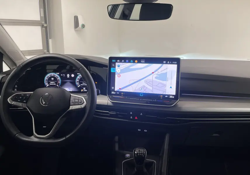 Intérieur de la Volkswagen Golf 1.5 TSI 2024, tableau de bord moderne avec écran tactile et boîte manuelle visible.