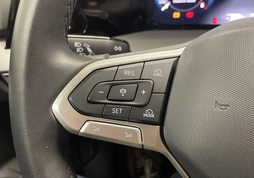 Gros plan sur les commandes de régulateur de vitesse au volant d'une Volkswagen Golf 2024, finition VW Edition.