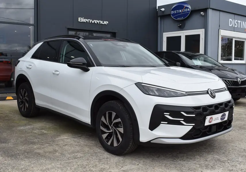 Volkswagen T-Roc blanc vue 3/4 avant droit avec toit noir et jantes alliage bicolores.