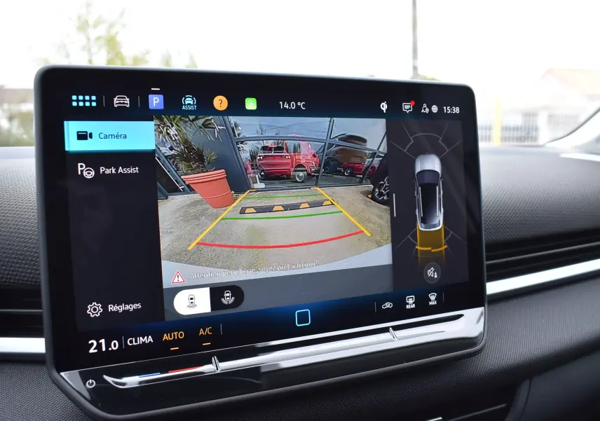 Écran tactile intérieur montrant la caméra de recul avec vue arrière et aides au stationnement activées.