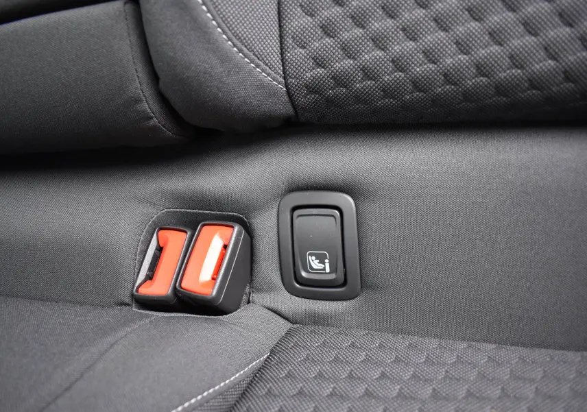 Détail des attaches ISOFIX rouges sur la banquette arrière en tissu gris du Volkswagen T-Roc 2025.