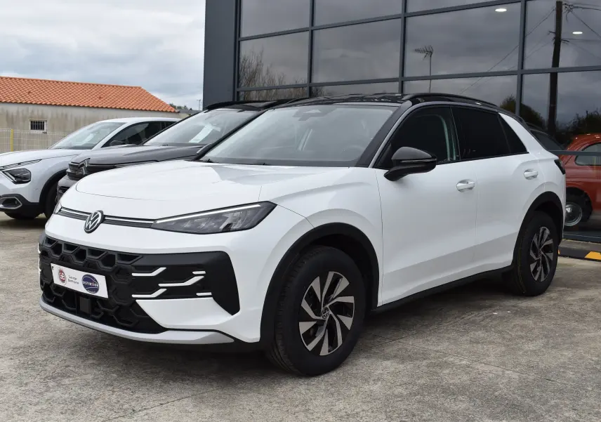 Volkswagen T-Roc blanc vue 3/4 avant droit avec toit noir et jantes alliage modernes.
