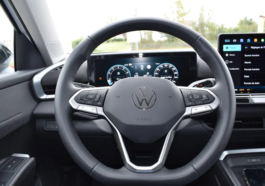 Vue intérieure centrée sur le volant multifonction cuir noir et l'écran digital du tableau de bord du Volkswagen T-Roc.