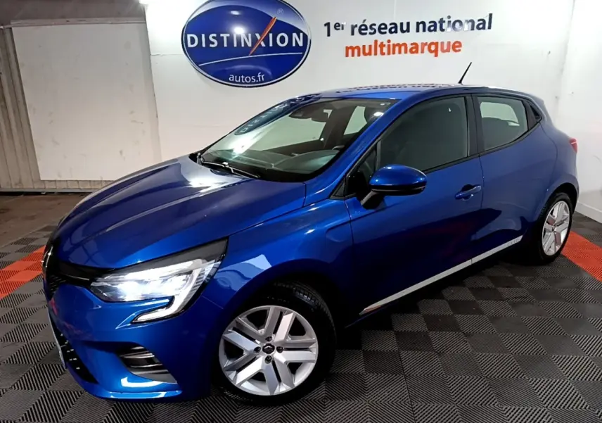 Renault Clio Business bleu vue 3/4 avant droit, phares LED allumés, jantes alliage, dans un showroom intérieur.