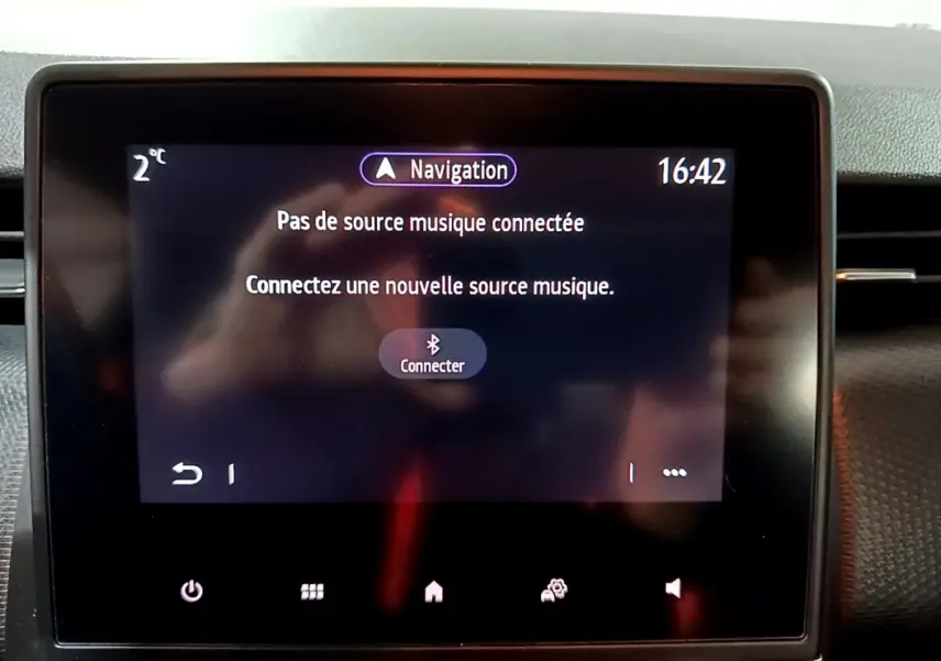 Écran tactile central de la Renault Clio Business bleu, affichant le message de connexion musique Bluetooth.