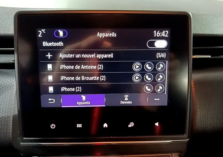 Écran tactile central de la Renault Clio Business bleu 2022 affichant le menu Bluetooth avec plusieurs appareils connectés.