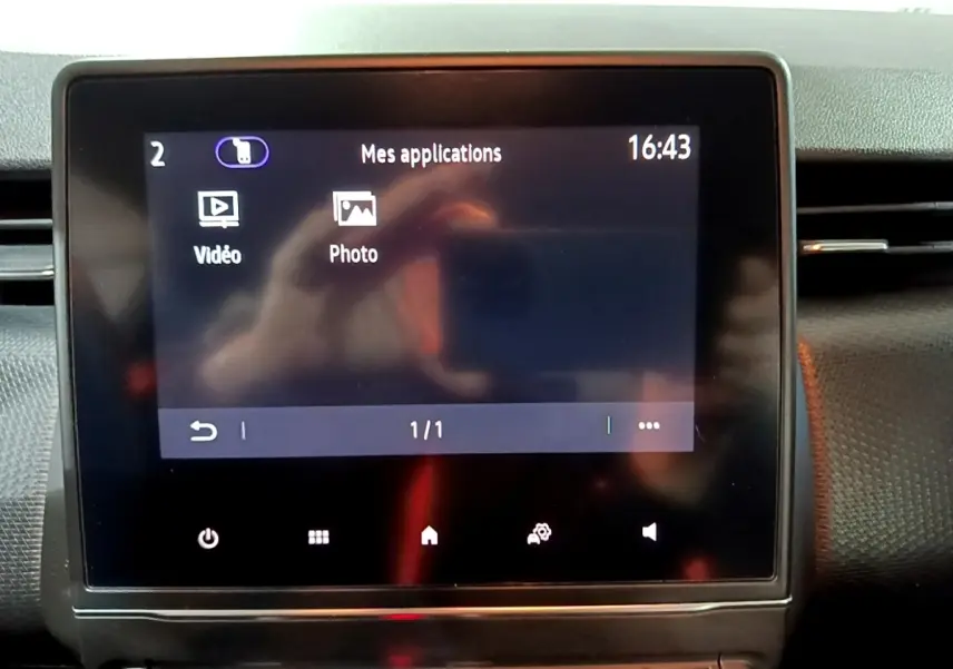Écran tactile central du tableau de bord de la Renault Clio Business bleu, affichant le menu applications à 16h43.