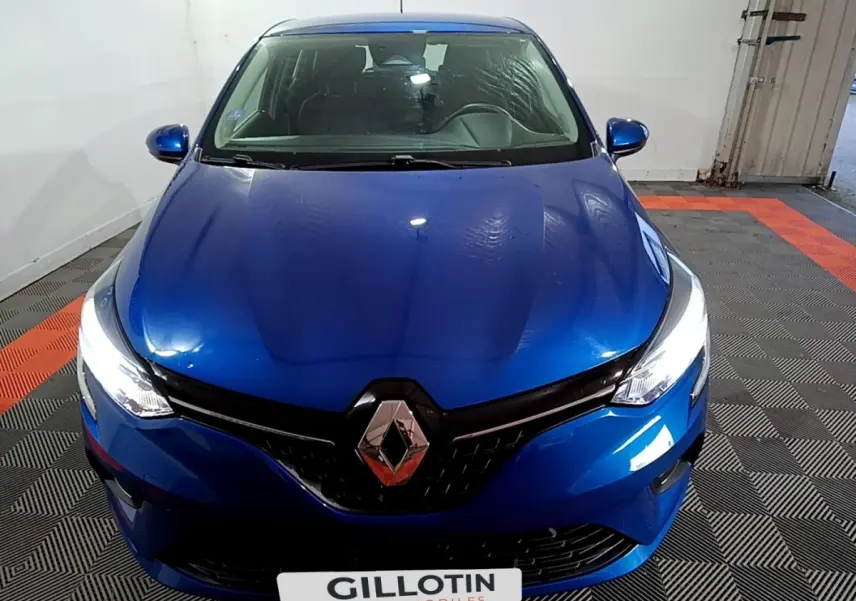 Vue avant rapprochée d’une Renault Clio Business bleu, avec phares LED allumés et logo Renault central bien visible.