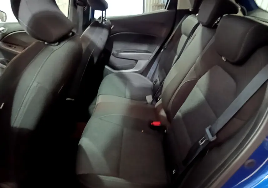 Vue intérieure côté droit montrant la banquette arrière noire de la Renault Clio Business SCe 65, porte ouverte bleu visible.