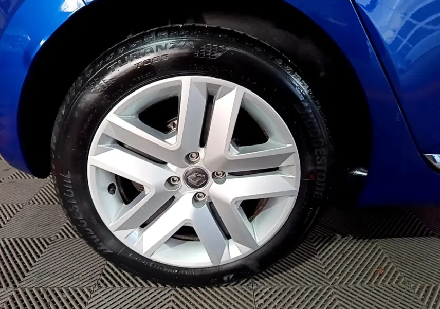 Gros plan sur la roue avant gauche d’une Renault Clio Business bleu, avec jante alliage et pneu Bridgestone.