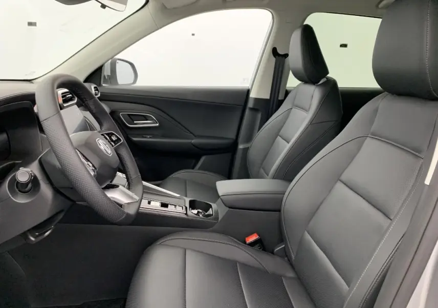 Vue intérieure côté conducteur du MG ZS 1.5 L HYBRID+ 197 CH Luxury 2026, sièges en cuir noir et tableau de bord moderne.